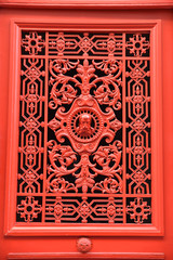 Porte en bois rouge à décor en fer forgé