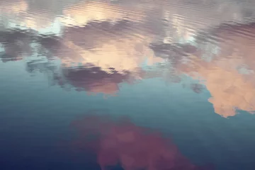 reflection of blue sky with white clouds in water, abstract background. © redchanka