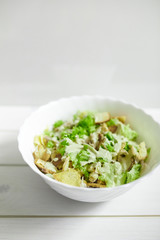 Mixed salad with green apple and walnuts on the table