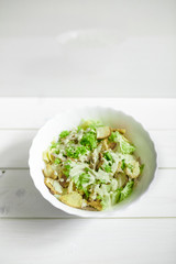 Mixed salad with green apple and walnuts on the table