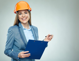 Smiling business woman builder holding clipboard with pen.