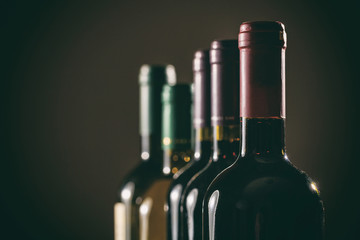 Wine bottles on black background, copy space