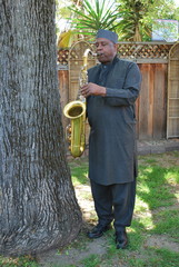 Muslim male jazz musician with his tenor saxophone outdoors.