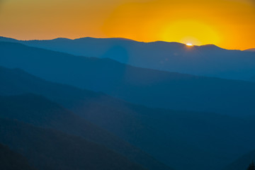 Obraz premium Glorious Sunrise over the Great Smoky Mountains layered blue ridges to the orange yellow horizon