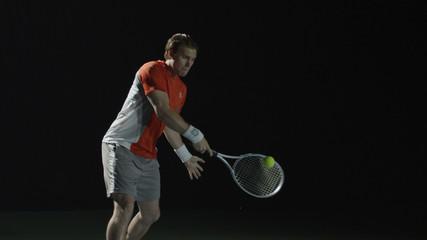 Fototapeta na wymiar Man hitting tennis ball with racket, isolated on black