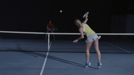 Man and woman opposing each other on tennis court