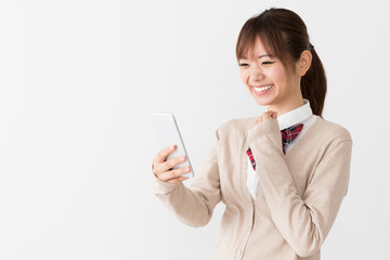 スマートフォンを使う女子高生