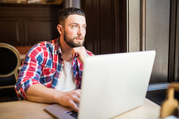 Smiling man using laptop in restaurant working