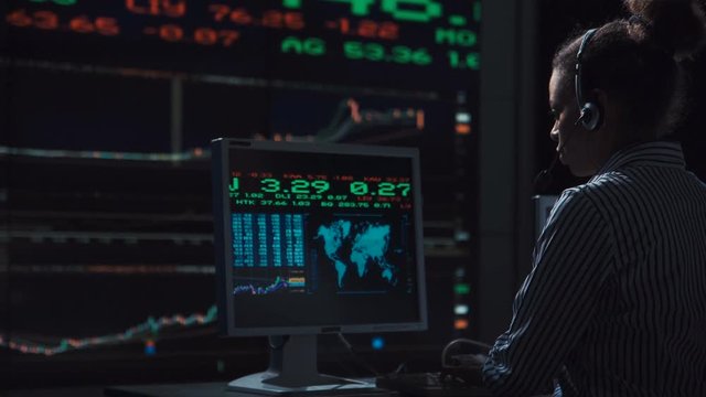 Sad woman stock broker working in futuristic office with live global market feed displays.