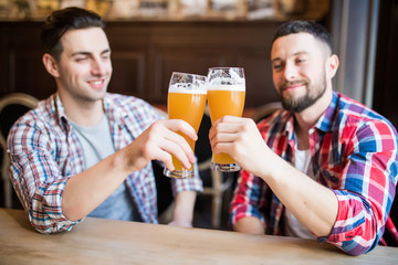 Cheers, my friend. Two handsome men is celebrating meeting and smiling.