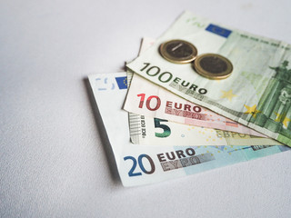 Euro banknotes and coins on white background.