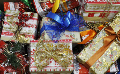 a lot of nicely wrapped Christmas gifts are in the same place , tied with different ribbons, tinsel, beads, flowers. gift wrap with a festive theme, it is beautiful, shiny.