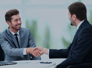 Two business colleagues shaking hands during meeting