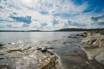 Landscape on a large lake with a stone beach on a summer day. Ladoga Lake, Karelia