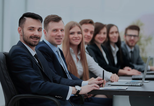 Confident businessman looking at camera among colleagues