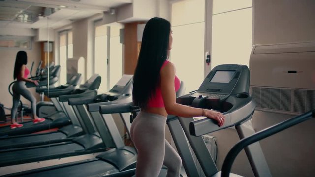 Athletic young woman working out on stepper machine at the gym, fitness club. 4 k