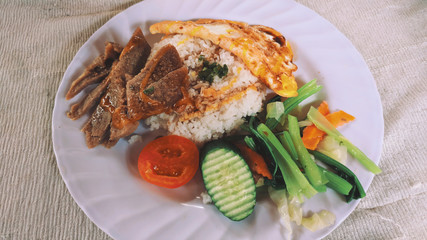 Grilled chicken breast with cooked vegetable on plates.
