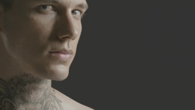 Handsome sexy young man stylish with tattoo on his neck, torso and hand - ultra close up body and face detail - greenscreen Prores - cinematic lighting