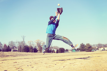 Boy catching a baseball, sandlot baseball, focus on shirt. © soupstock