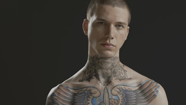 Handsome sexy young man stylish with tattoo on his neck, torso and hand - middle shot portrait studio - Prores - cinematic fashion lighting