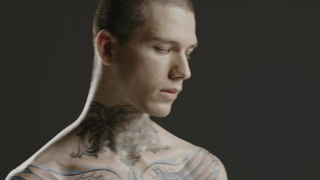 Handsome sexy young man stylish with tattoo on his neck, torso and hand - middle shot portrait studio - Prores - cinematic fashion lighting