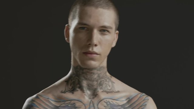 Handsome sexy young man stylish with tattoo on his neck, torso and hand - middle shot portrait studio - Prores - cinematic fashion lighting