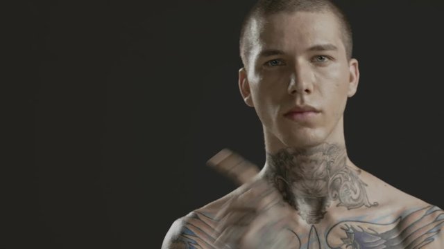 Handsome sexy young man stylish with tattoo on his neck, torso and hand - middle shot portrait studio - Prores - cinematic fashion lighting