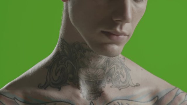 Handsome sexy young man stylish with tattoo on his neck, torso and hand - ultra close up - greenscreen Prores - cinematic lighting