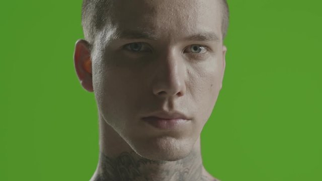 Handsome sexy young man stylish with tattoo on his neck, torso and hand - ultra close up - greenscreen Prores - cinematic lighting