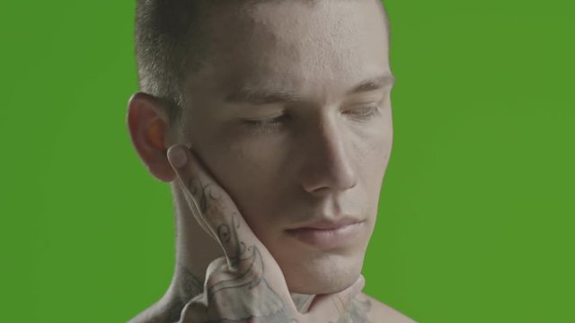 Handsome sexy young man stylish with tattoo on his neck, torso and hand - ultra close up - greenscreen Prores - cinematic lighting