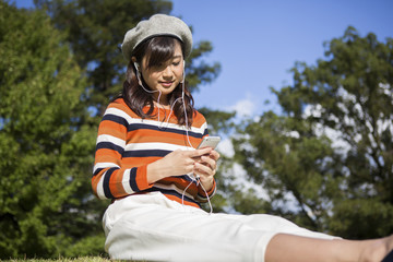 Fototapeta premium 公園で音楽を聴く女性