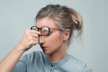 Fototapeta premium Tired woman has eyes pain. Optician and eyeglasses