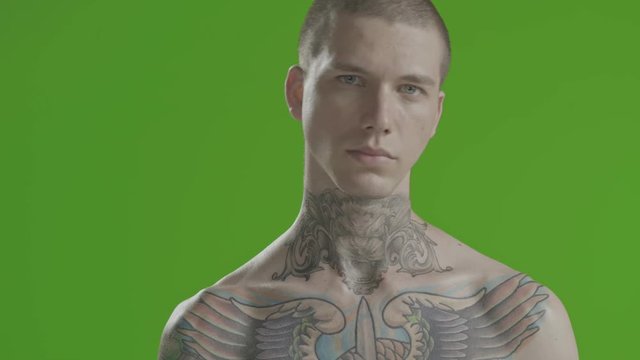Handsome sexy young man stylish with tattoo on his neck, torso and hand - middle shot portrait studio - greenscreen Prores - cinematic lighting