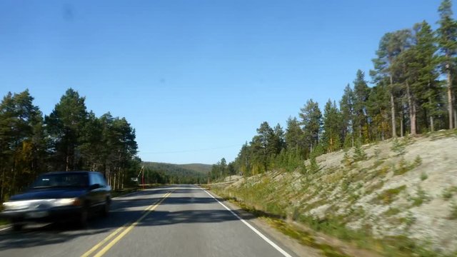 Autumn color road, Hyper time lapse driving on route e75 full of different fall colors, from inari towards utsjoki, on a sunny autumn day, in Lapland, Finland