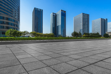 modern glass building exterior with empty pavement under blue sky, china