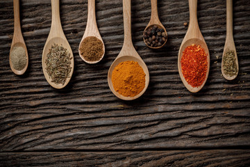 Herbs and spices and the spoon on the wooden table