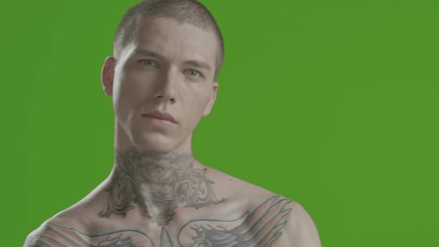 Handsome sexy young man stylish with tattoo on his neck, torso and hand - middle shot portrait studio - greenscreen Prores - cinematic lighting