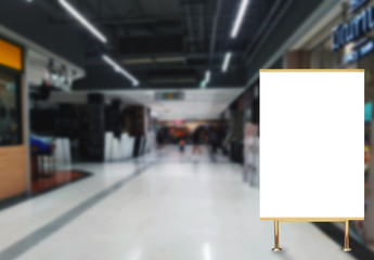 Blank billboard advertising stand in shopping mall blurred background ,commercial, marketing and advertisement concept
