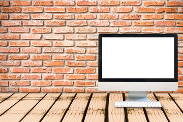 Modern computer blank monitor screen on wooden table with brick wall texture background