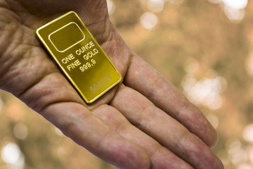 A small ingot of gold in the hand. One ounce of gold. To give gold.