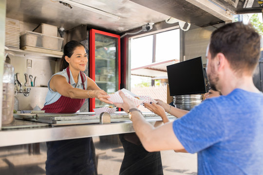 Woman In Food Truck Selling Hot Dogs