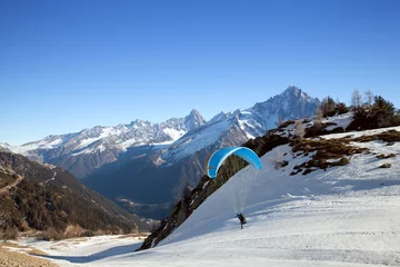 Tuinposter A paraglider is starting his fly in Chamonix valley, France © anrymos