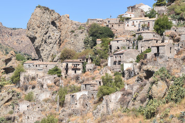Dead city/Ruined and abandoned as a result of earthquake houses at the foot of a high rock.