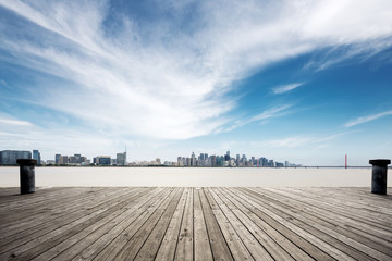 empty wooden floor with modern bridge and buildings