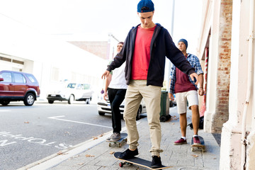 Teenage friends walking at the street with skateboards