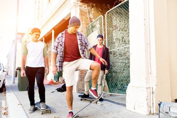 Fototapeta premium Teenage friends walking at the street with skateboards