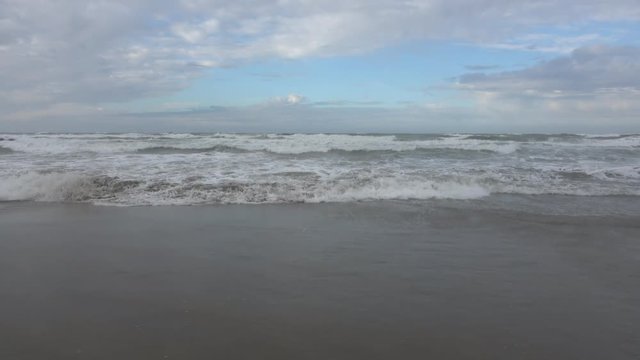 Waves rolling on the beach is a stormy day, winter mediterranean sea. Focene, Lazio, Italy. 4k