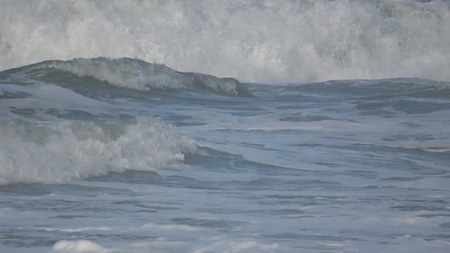 Waves rolling on the beach is a stormy day, winter mediterranean sea. Focene, Lazio, Italy. Slow motion