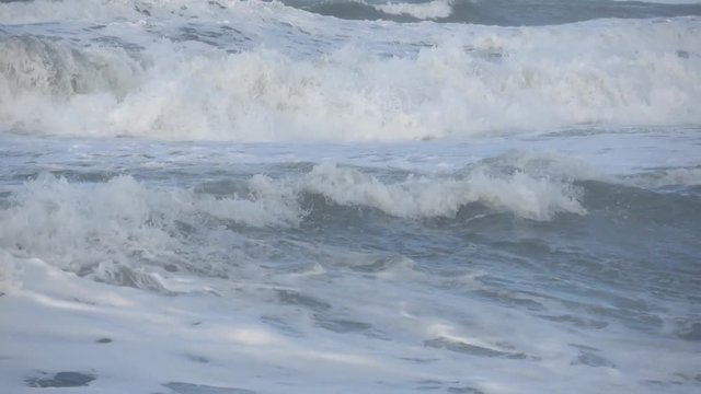 Waves rolling on the beach is a stormy day, winter mediterranean sea. Focene, Lazio, Italy. Slow motion