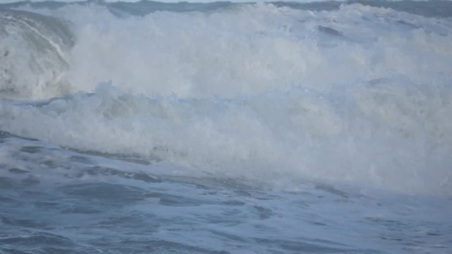 Waves rolling on the beach is a stormy day, winter mediterranean sea. Focene, Lazio, Italy. Slow motion
